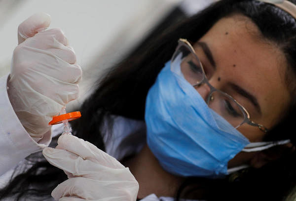 A pharmacist doctor works on the basics of the raw materials for the coronavirus disease treatment drugs. Credit: Reuters