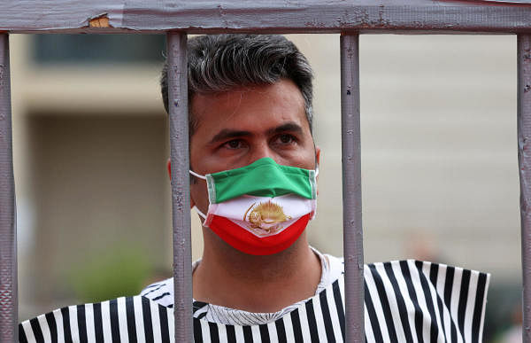 A protester wears a mask bearing the Iranian Flag. Credit: Reuters