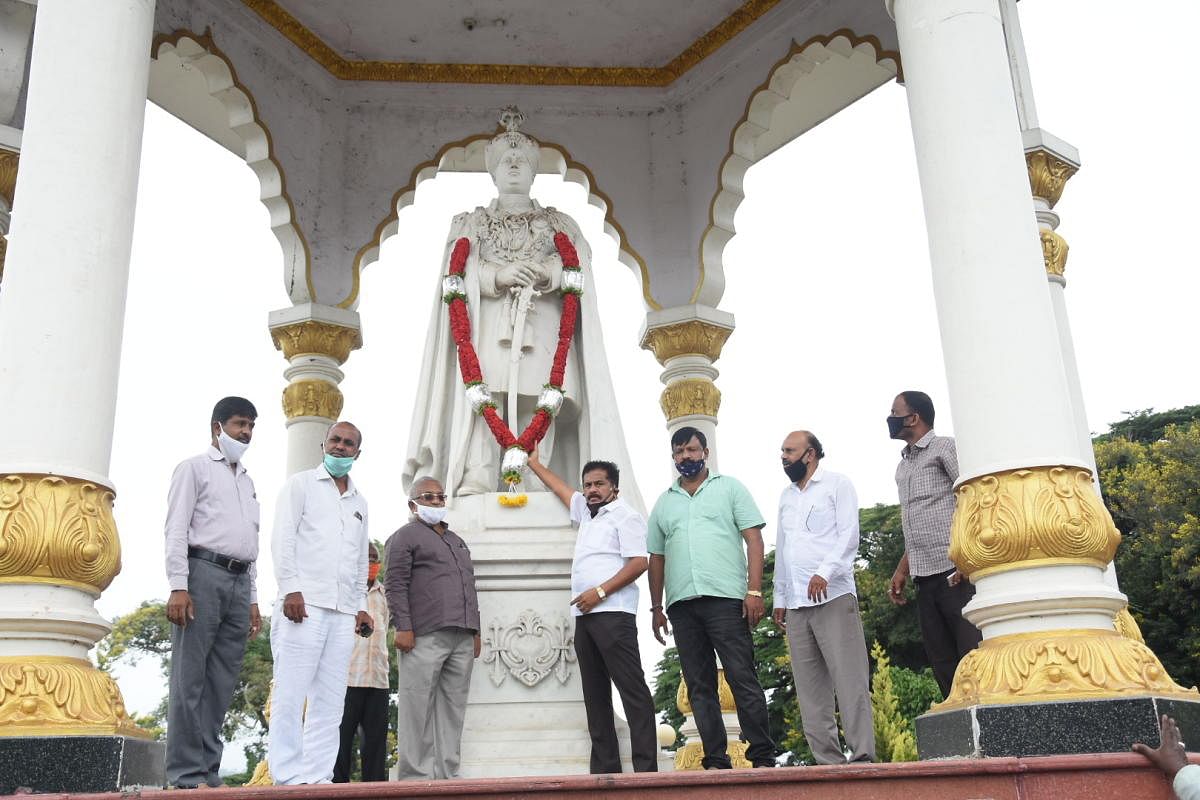 Former MLA M K Somashekar pays floral tributes to the statue of Jayachamaraja Wadiyar to mark his 101st birth anniversary in Mysuru on Saturday. Congress city unit president R Murthy is seen. DH PHOTO