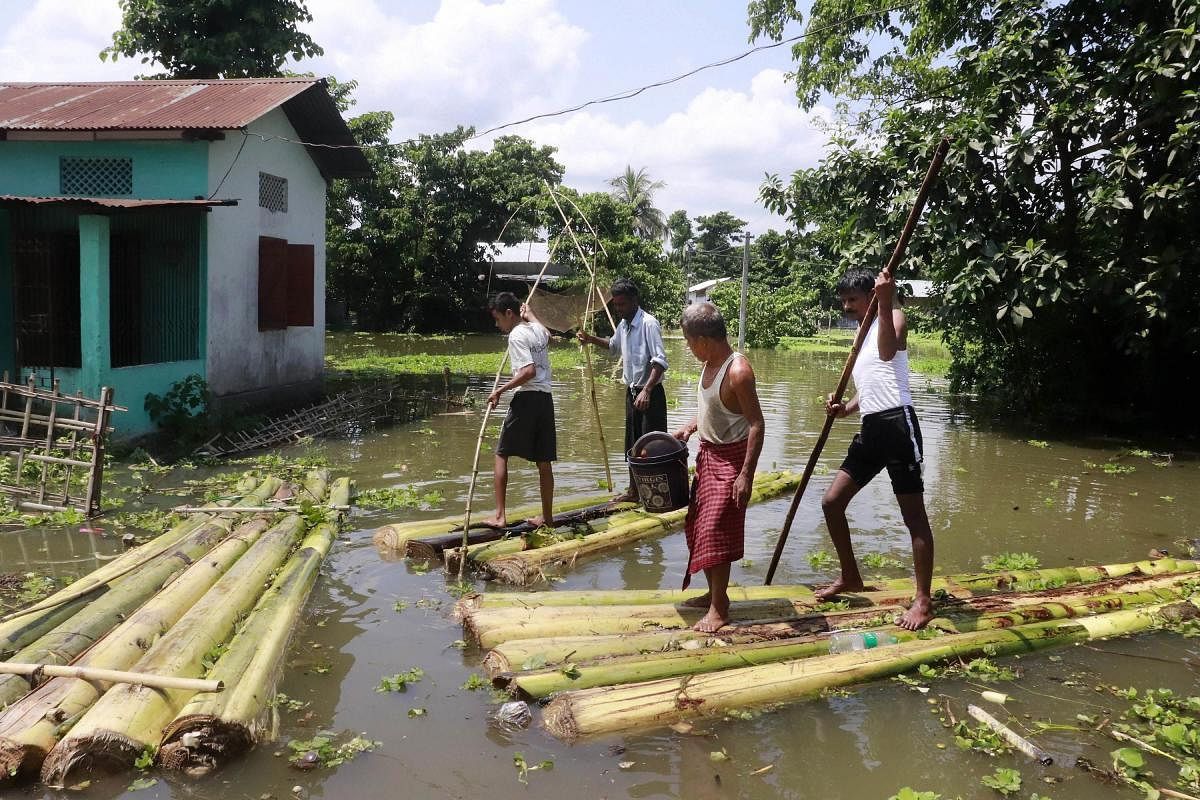 Villagers wade through a flood affected area on makeshift rafts, at Tezpur in Sonitpur district, Saturday, July 18, 2020. (PTI Photo)