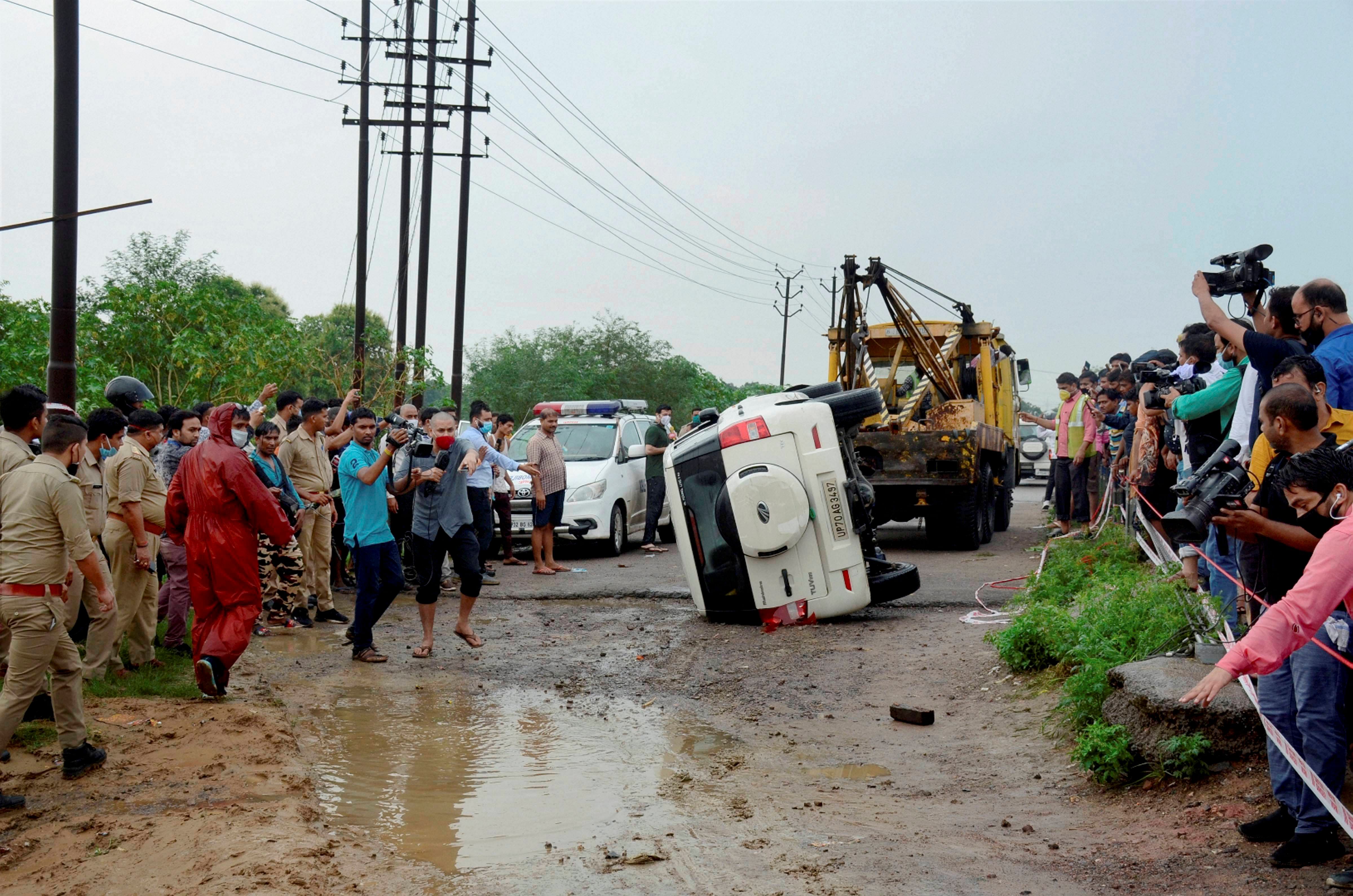 Police and media at the encounter site where gangster Vikas Dubey was killed when he allegedly tried to escape from the spot following an accident  Credit: PTI Photo