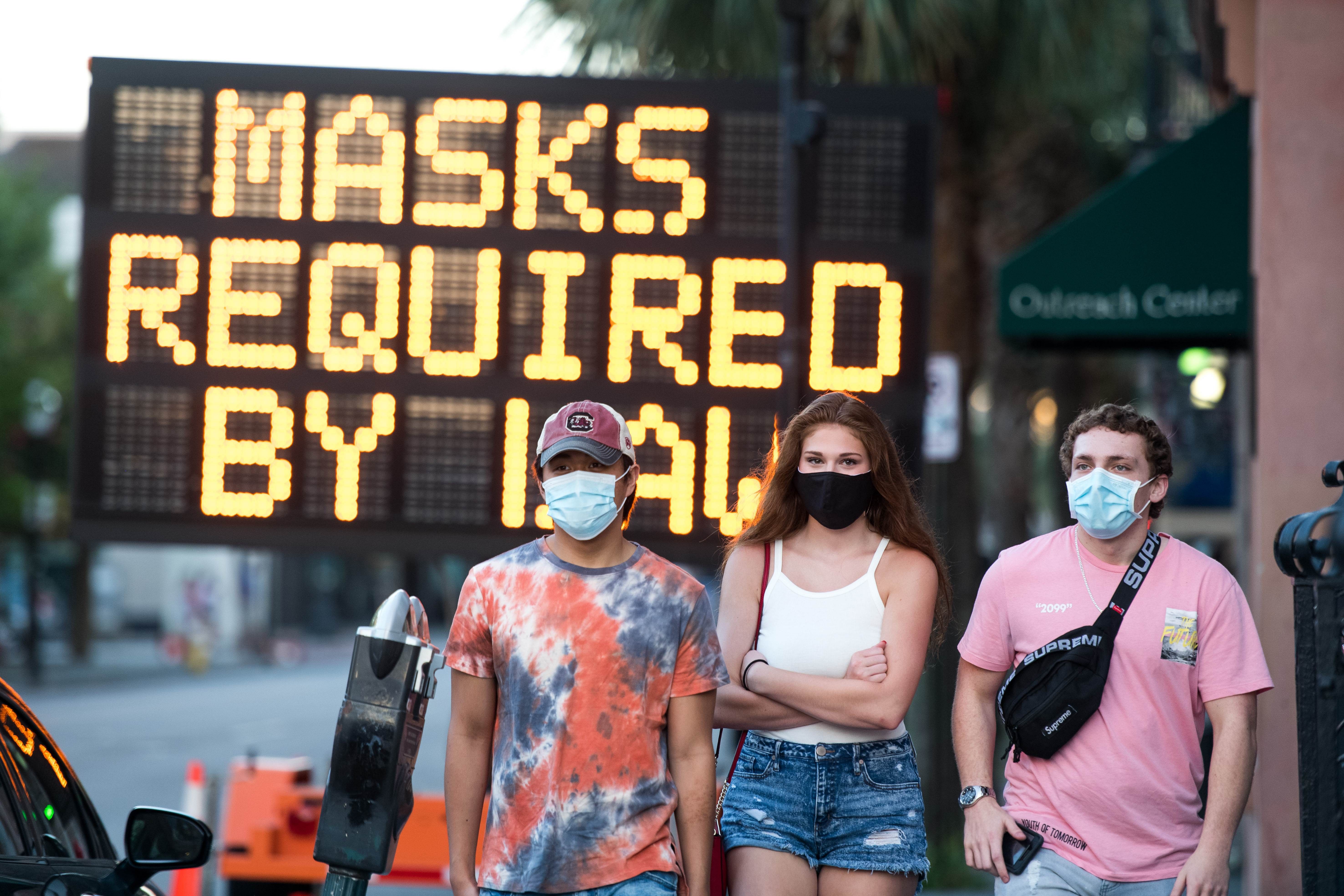 People wearing protective face masks walk along King St. on July 18, 2020 in Charleston, South Carolina. Credit: AFP Photo