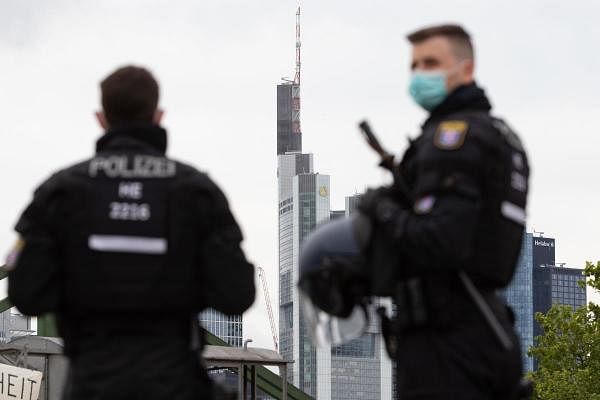 Police officers wearing face masks are pictured in front of Commerzbank and Helaba headquarters during a rally against restrictions in place to limit the spread of the new coronavirus pandemic in Frankfurt am Main, western Germany. Credit: AFP Photo