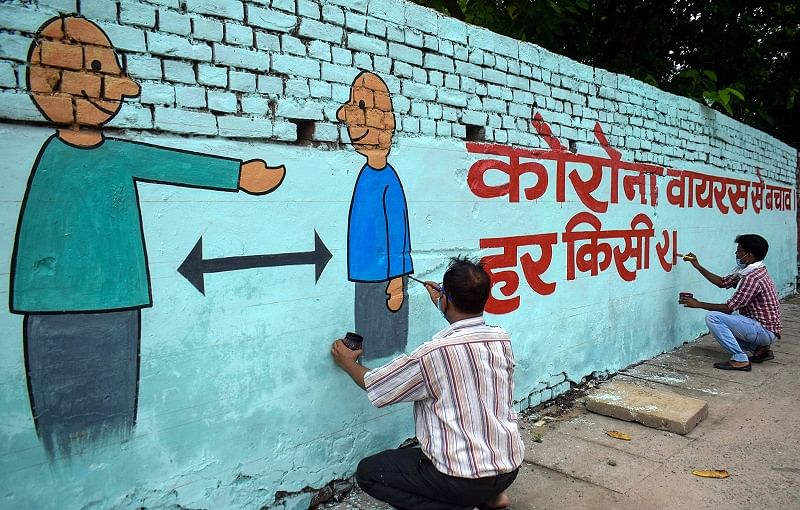 Artists paint graffiti on a wall, during the total lockdown imposed in the wake of coronavirus pandemic, in Prayagraj. Credits: PTI Photo