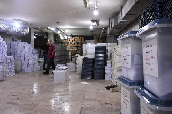 A Syrian man looks at ballot boxes, ahead of handing them over to the police to deliver them to polling stations on the eve of the parliamentary elections, in the Syrian city of Aleppo. Credit: AFP