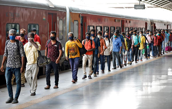 Migrant workers and their families, who had left during a lockdown, walk at a platform after they returned from their home state of Uttar Pradesh. Credit: Reuters Photo