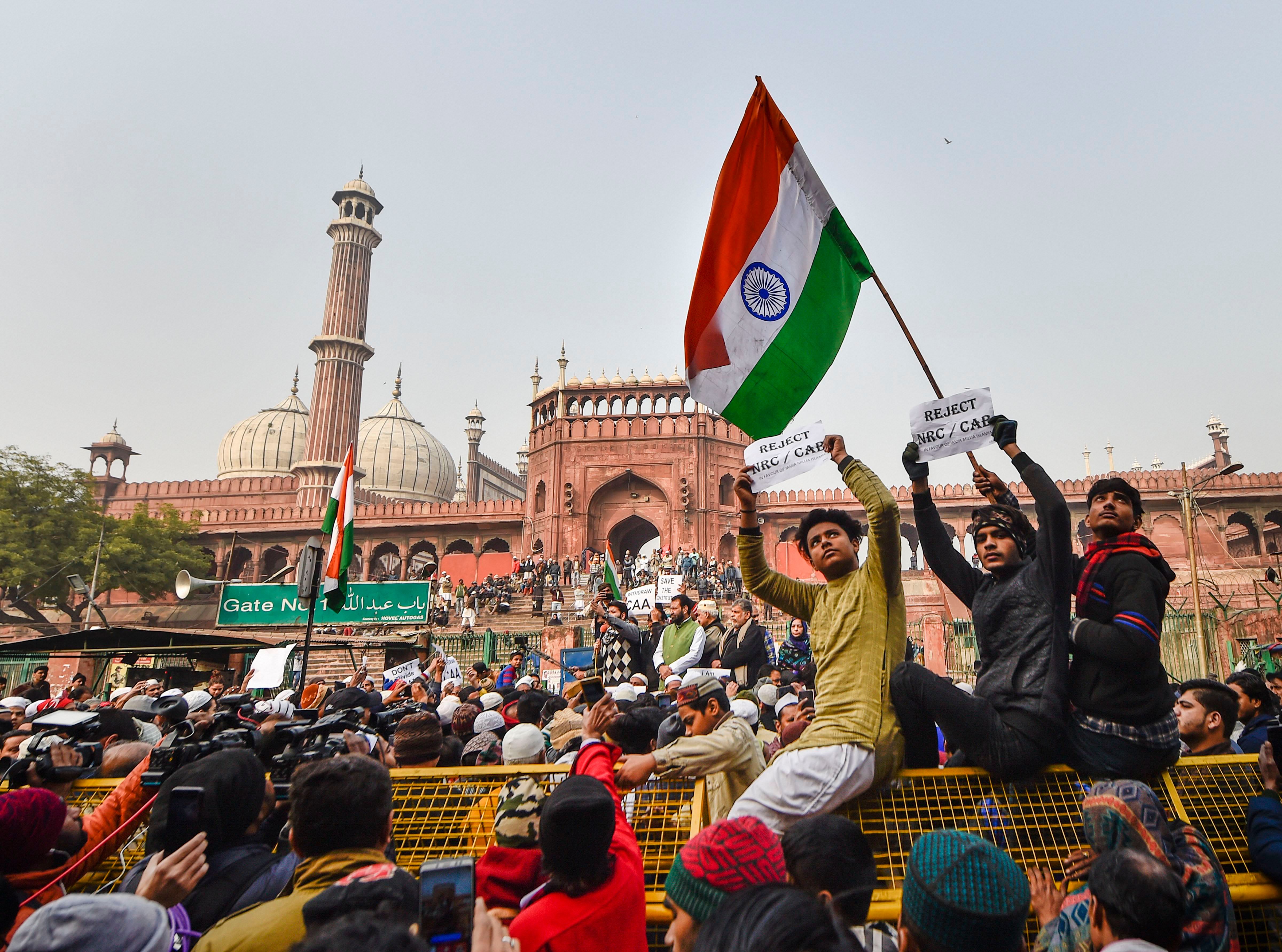 A protestor holds the national flag during a protest against Citizenship (Amendment) Act, after Friday prayers, at Jama Masjid in New Delhi, Friday, Dec. 27, 2019. Credit: PTI Photo