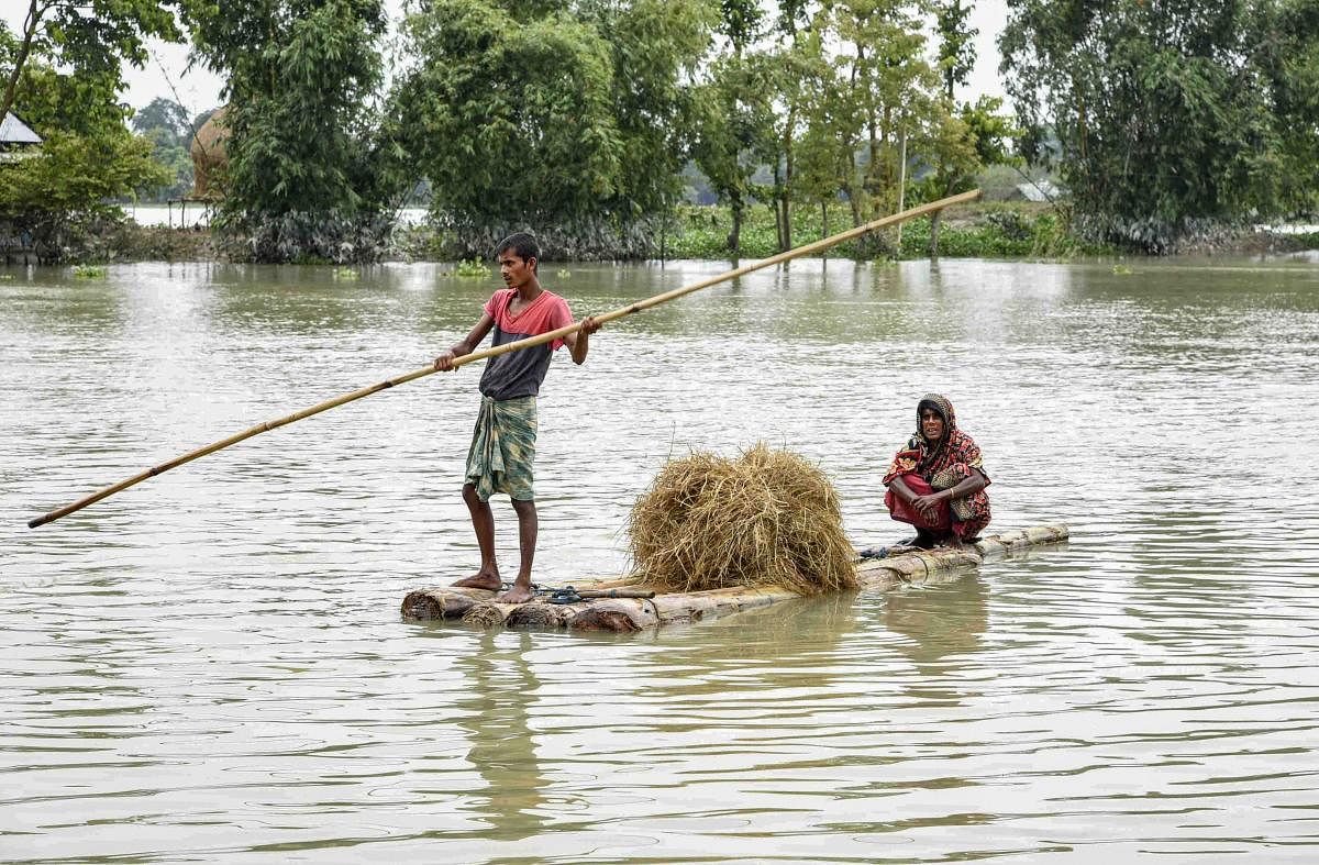 Morigaon: Villagers row a makeshift banana raft to cross a flood-affected village, in Morigaon district, Saturday, July 18, 2020. (PTI Photo)(PTI18-07-2020_000147B)