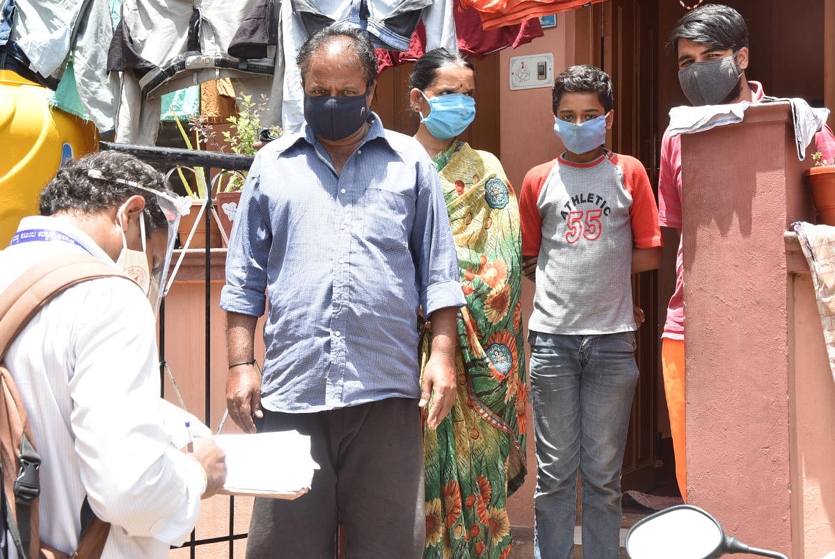 Health department personnel conduct a door-to-door survey for Covid symptoms as part of the rapid test, in Narasimharaja Assembly segment in Mysuru recently. DH PHOTO