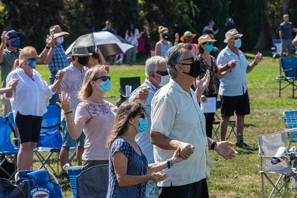 People wearing facemaks attend an outdoor Sunday service at Saints Simon & Jude Catholic Church in Huntington Beach, California, USA. Credit: AFP Photo