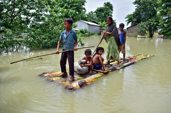 Villagers row a makeshift raft through a flooded field to reach a safer place at the flood-affected Mayong village in Morigaon district, in the northeastern state of Assam, India. Credit: Reuters Photo