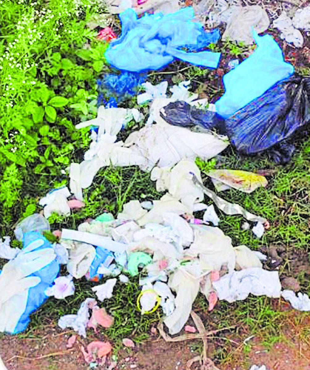 Personal Protective Equipment (PPE) kits, used by healthcare personnel and other bio-medical waste dumped besides a road near Mysuru Pinjarapole Society, at the foot of Chamundi Hill in Mysuru on Wednesday.