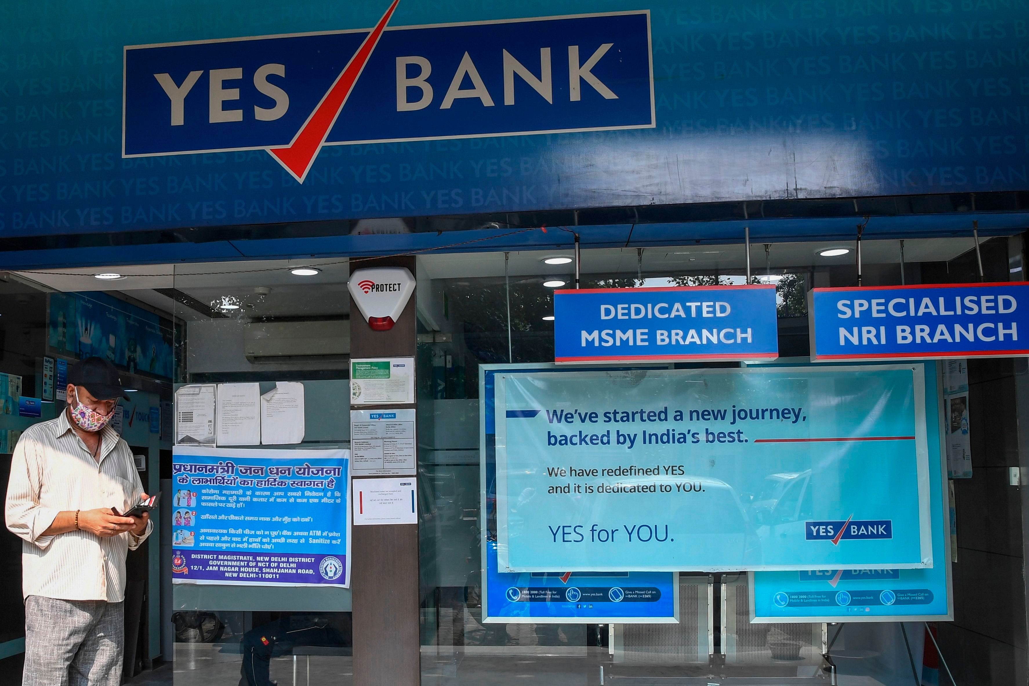 A man walks past a Yes Bank branch in New Delhi. Credits: AFP Photo