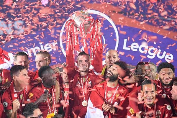 Liverpool's English midfielder Jordan Henderson lifts the Premier League trophy following the English Premier League football match between Liverpool and Chelsea at Anfield. Credit: AFP Photo