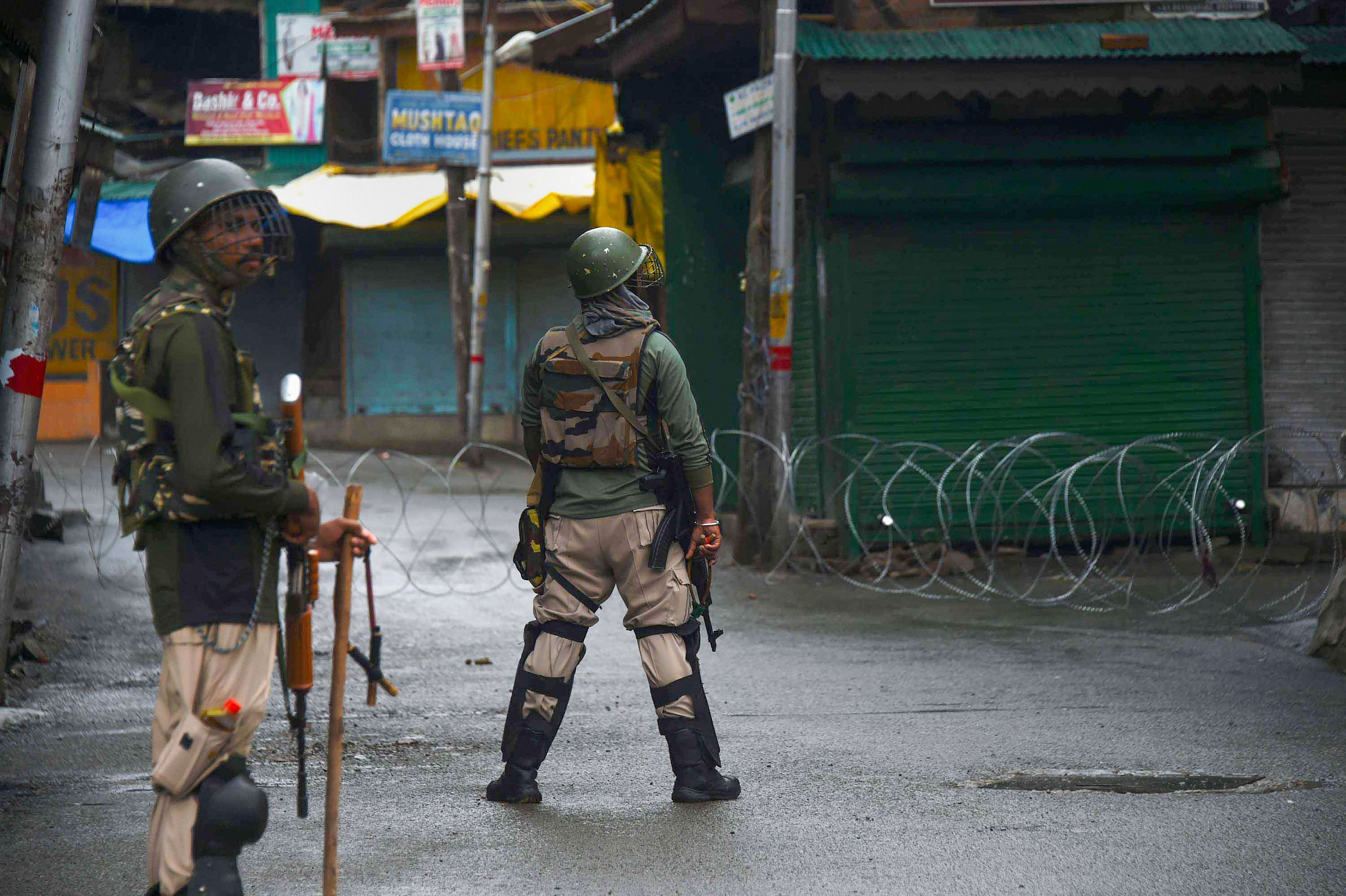 Security personnel stand guard in a street during curfew like restrictions following abrogation of the provisions of Article 370, in Srinagar, Wednesday, Aug. 14, 2019. Credit: PTI Photo