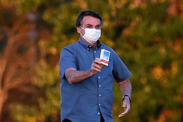 Brazilian President Jair Bolsonaro shows a box of hydroxychloroquine to supporters outside the Alvorada Palace in Brasilia. Credit: AFP Photo