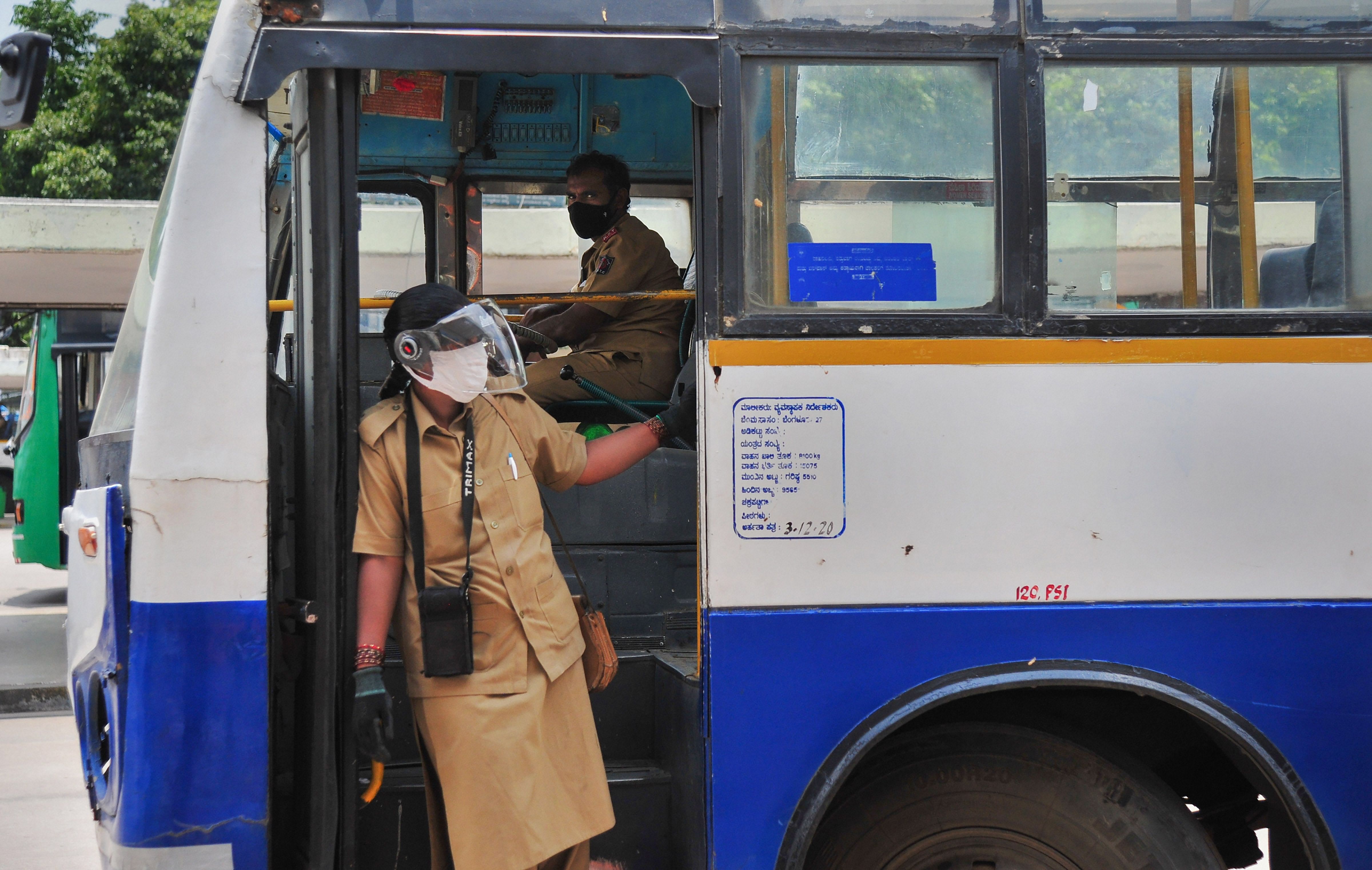A ticket conductor looks for passengers at Majestic bus stand as commercial activities resume after one week of the COVID-19 lockdown, in Bengaluru. Credit: PTI