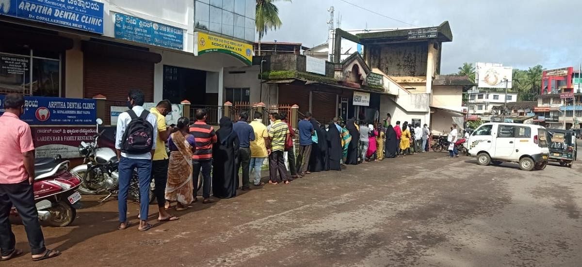 People wait in a long queue to give thumb impression for the ration cards at Belthangady. DH Photo