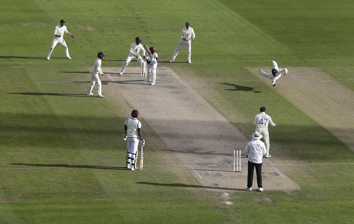 England's Ollie Pope, right, dives to take the catch to dismiss West Indies' Kemar Roach, third right, during the last day of the second cricket Test match between England and West Indies at Old Trafford in Manchester, England, Monday, July 20, 2020. Credit: AP Photo
