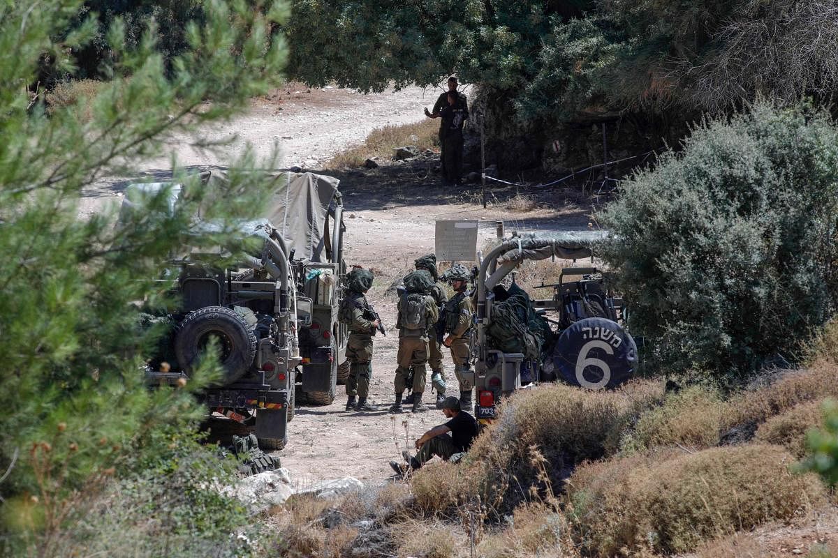  Israeli soldiers by their vehicles near the northern town of Rihaniya, near the border with Lebanon. Credit: AFP