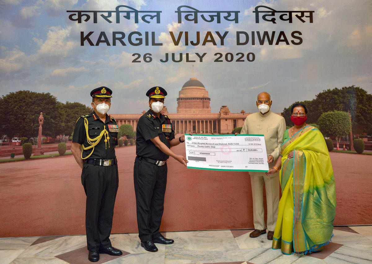 President Ram Nath Kovind along with First Lady Savita Kovind presents a cheque of Rs 20 lakh to the representatives of Army Hospital (Research and Referral), to buy equipment to combat the Covid-19 pandemic during an event on the occasion of 21st anniversary of the Kargil war victory. Credit: PTI