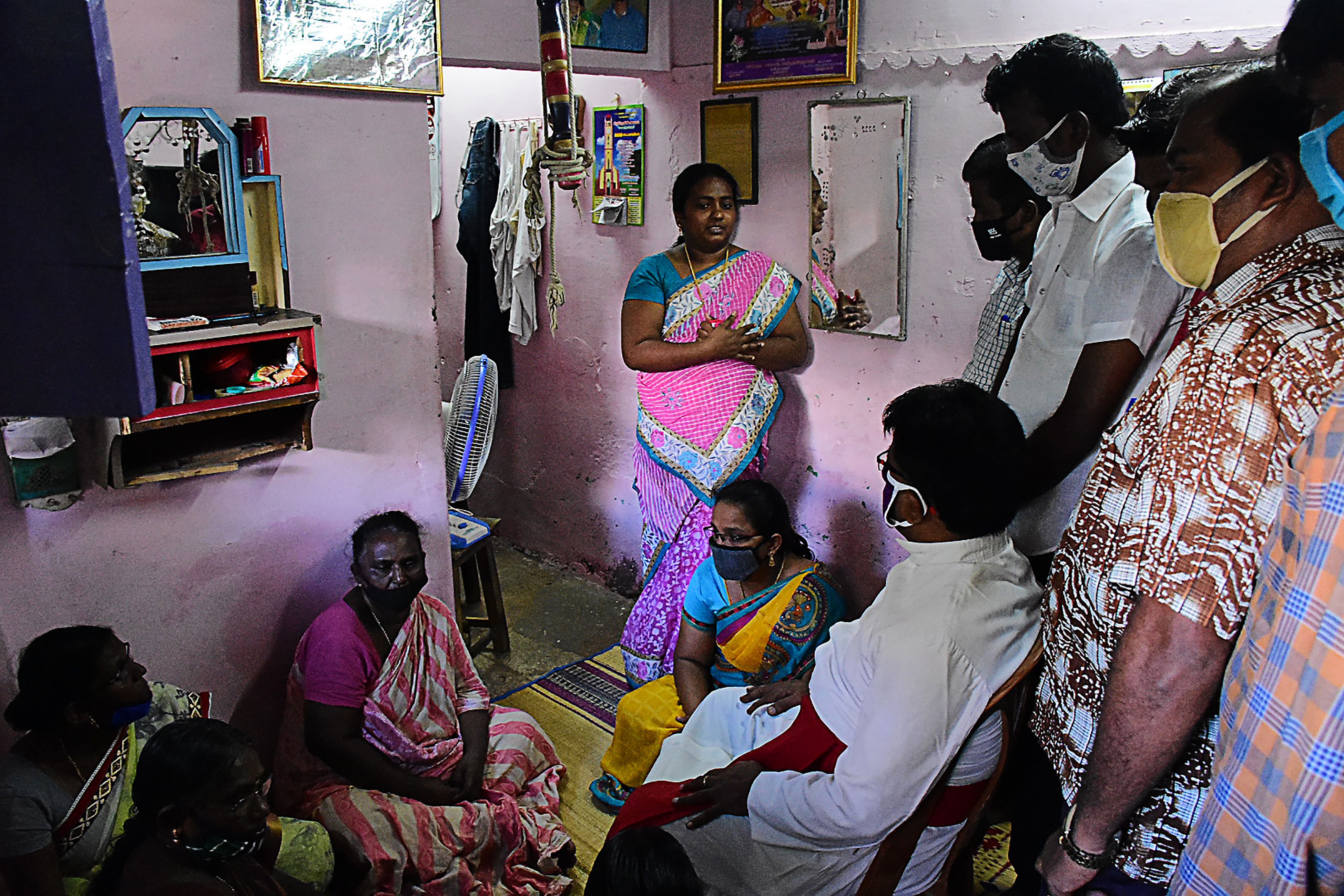 A church priest consoles family members of Jayaraj, 58, and son Bennicks Immanuel, 31, allegedly tortured at the hands of police in Sathankulam. Credit: AFP Photo