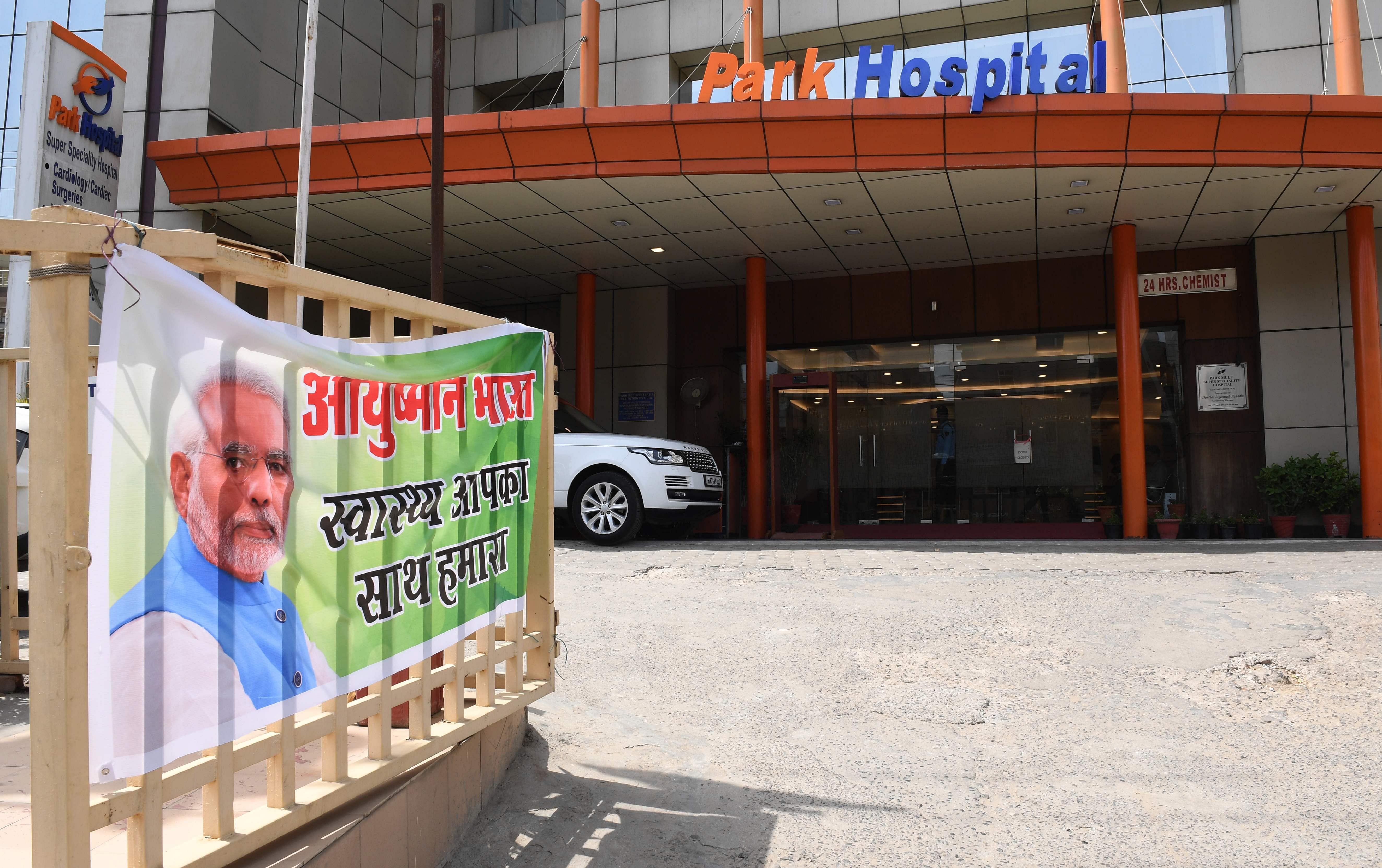A banner for Ayushman Bharat healthcare scheme, is pictured at a gate at Park Hospital in Gurgaon. Credit: AFP Photo