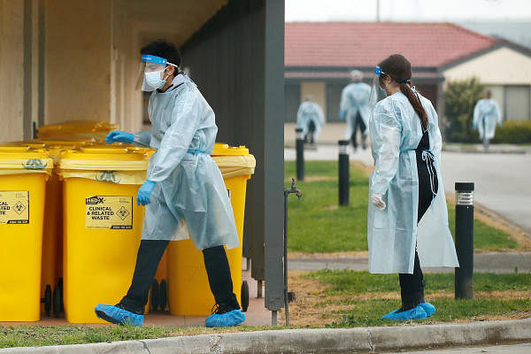 Medical staff dispose of clinical waste at an aged care facility experiencing an outbreak of Covid-19 in Melbourne. Credit: Reuters
