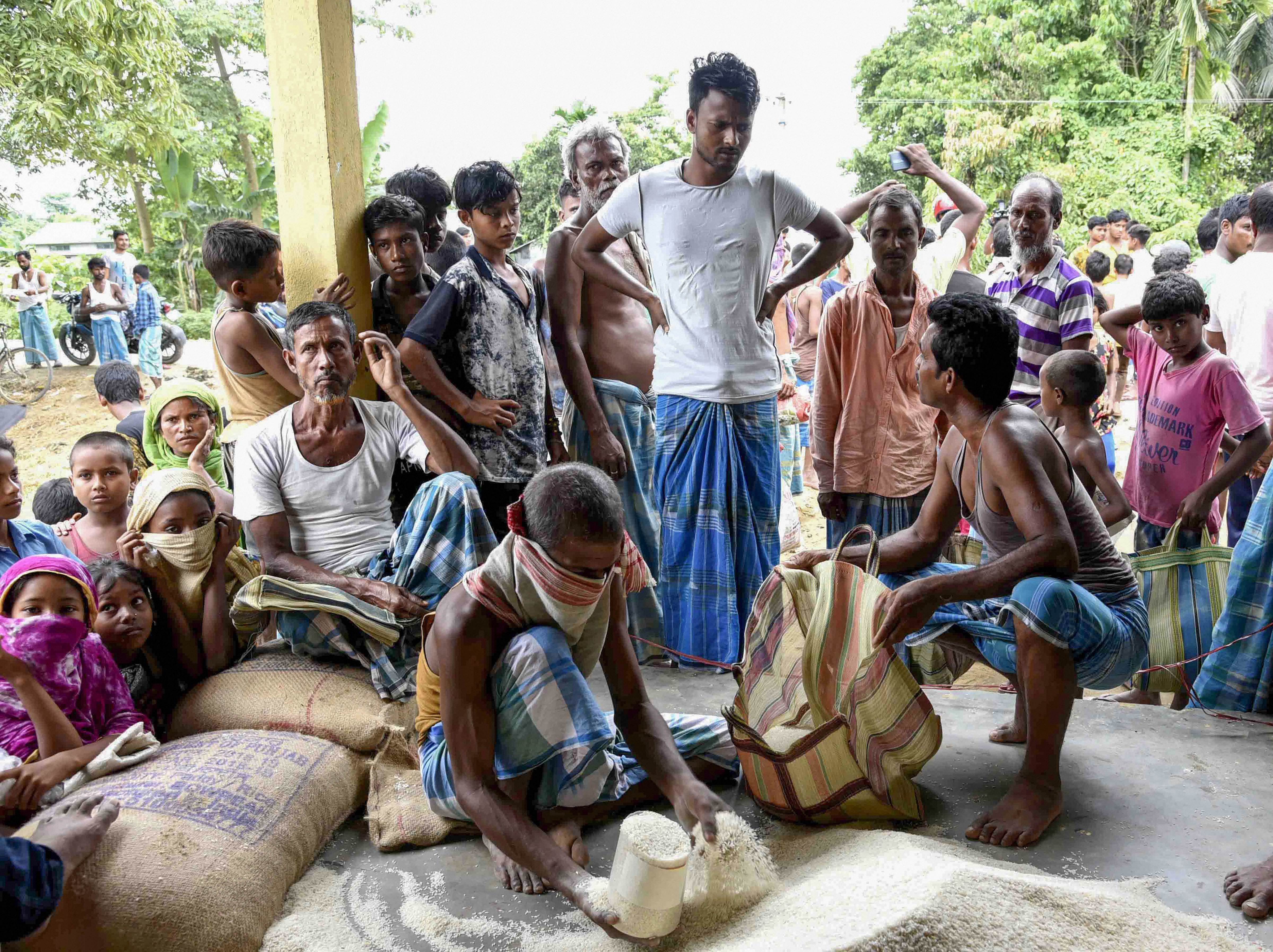 Villagers collect flood-relief ration, distributed by the state government, at Mayong in Morigaon district. Credit: PTI