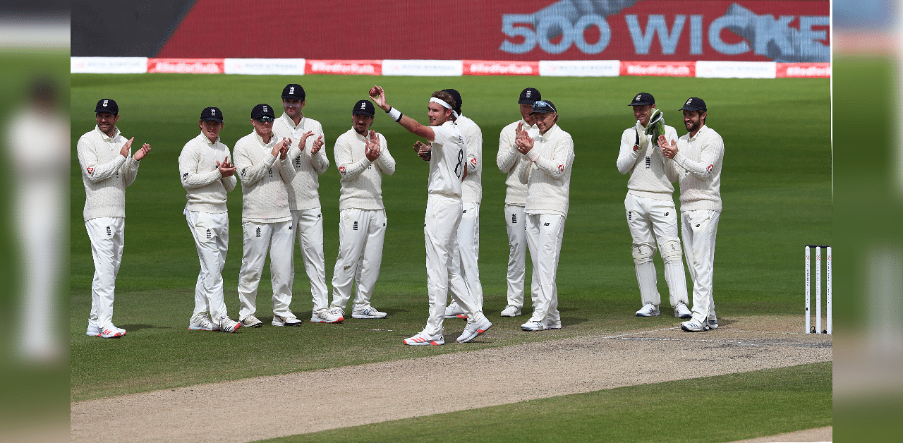 England's Stuart Broad, center, holds the ball up to celebrates taking 500 wickets during the fifth day of the third cricket Test match between England and West Indies at Old Trafford. Credit: AP Photo