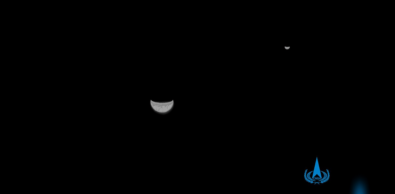 A view of the Earth and Moon taken by China's Tianwen-1 Mars probe from a distance of 1.2 million kilometers. - China's first Mars probe has left Earth's gravitational field and beamed back a photo of the planet and the Moon as it heads toward its destination. Credit: AFP Photo/China National Space Administration via CNS
