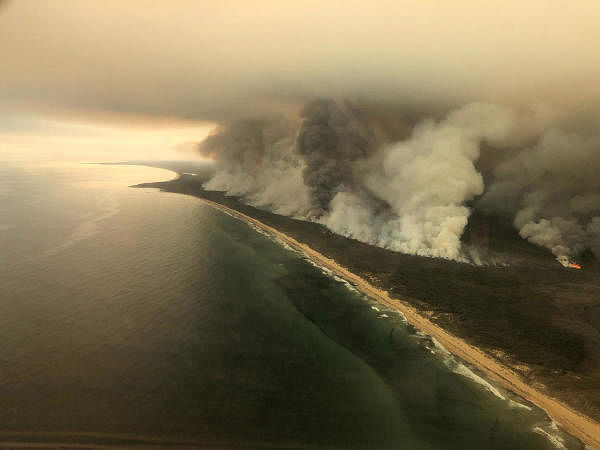 Thick plumes of smoke rise from bushfires at the coast of East Gippsland, Victoria, Australia January 4, 2020 in this aerial picture taken from AMSA Challenger jet. Credit: Australian Maritime Safety Authority/Handout via Reuters