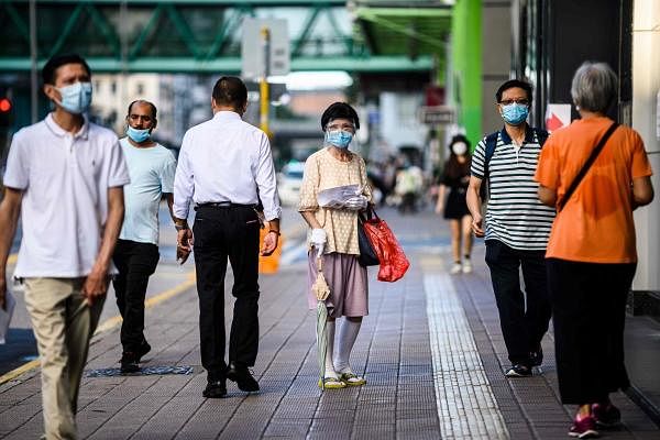 Pedestrians wear face masks in the Kowloon-side Sham Shui Po district of Hong Kong. Credit: AFP