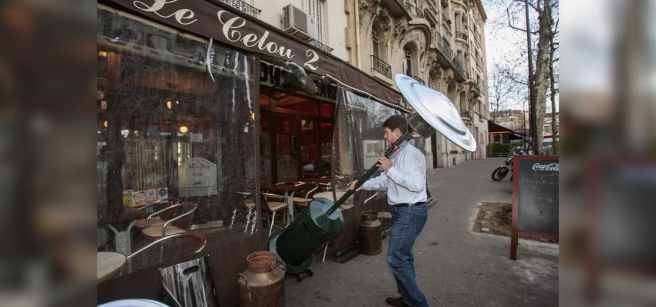 In this file photograph taken on January 8, 2008, a worker installs a heater on a cafe terrace in Paris. Credit: AFP