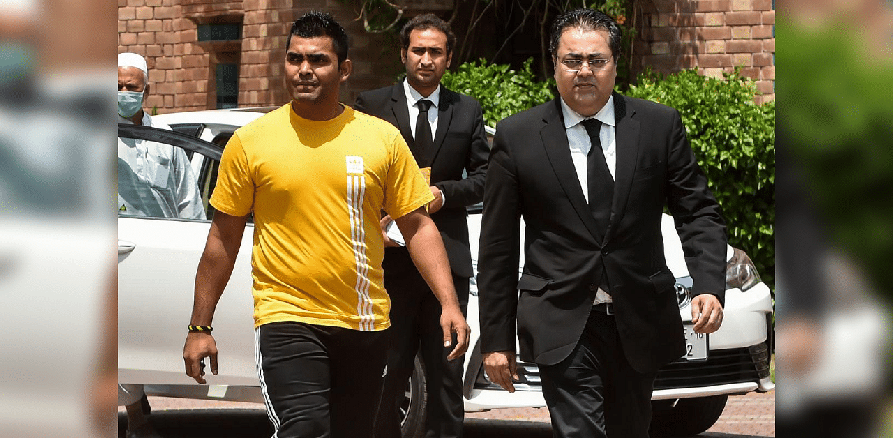 Cricketer Umar Akmal (L) with his lawyer. Credit: AFP File Photo