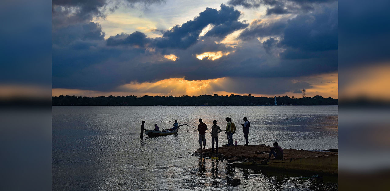 Silhouette of people fishing on the bank of Krishna river is seen during sunset, in Vijayawada. Credit: PTI File Photo