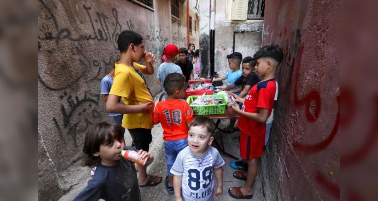 Palestinian children gather around a street vendor in the Amari refugee camp near the West Bank city of Ramallah. Credit: AFP