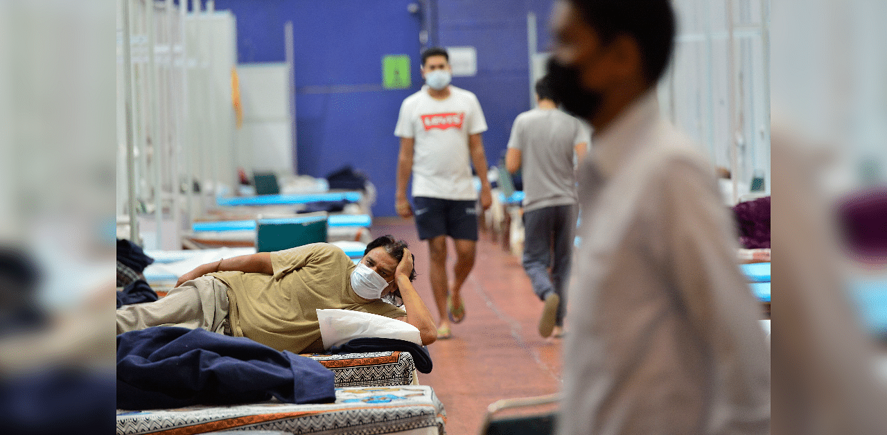 A recovered patient rests on a bed at CWG Village Covid care centre, during Unlock 2.0, near Akshardham in New Delhi. Credits: PTI Photo