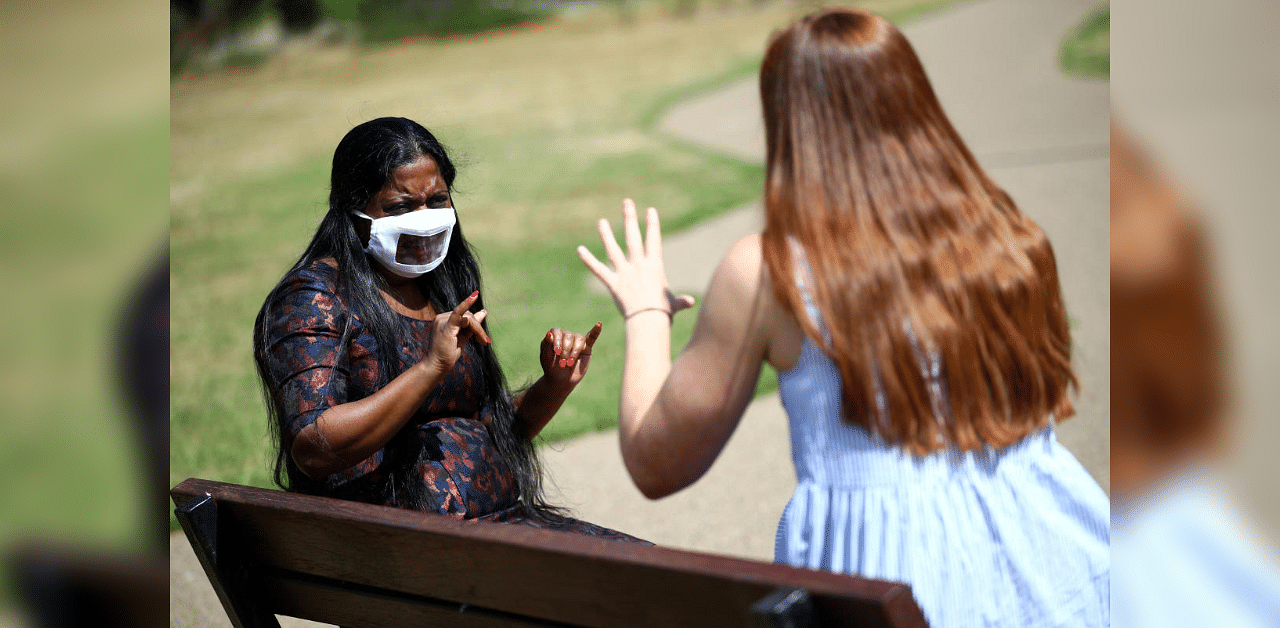 Director of Empowering Deaf Society Mangai Sutharsan uses sign language to communicate with interpreter Leanne Barsdell whilst wearing partially transparent masks, following the coronavirus disease (Covid-19) outbreak. Credit: Reuters Photo