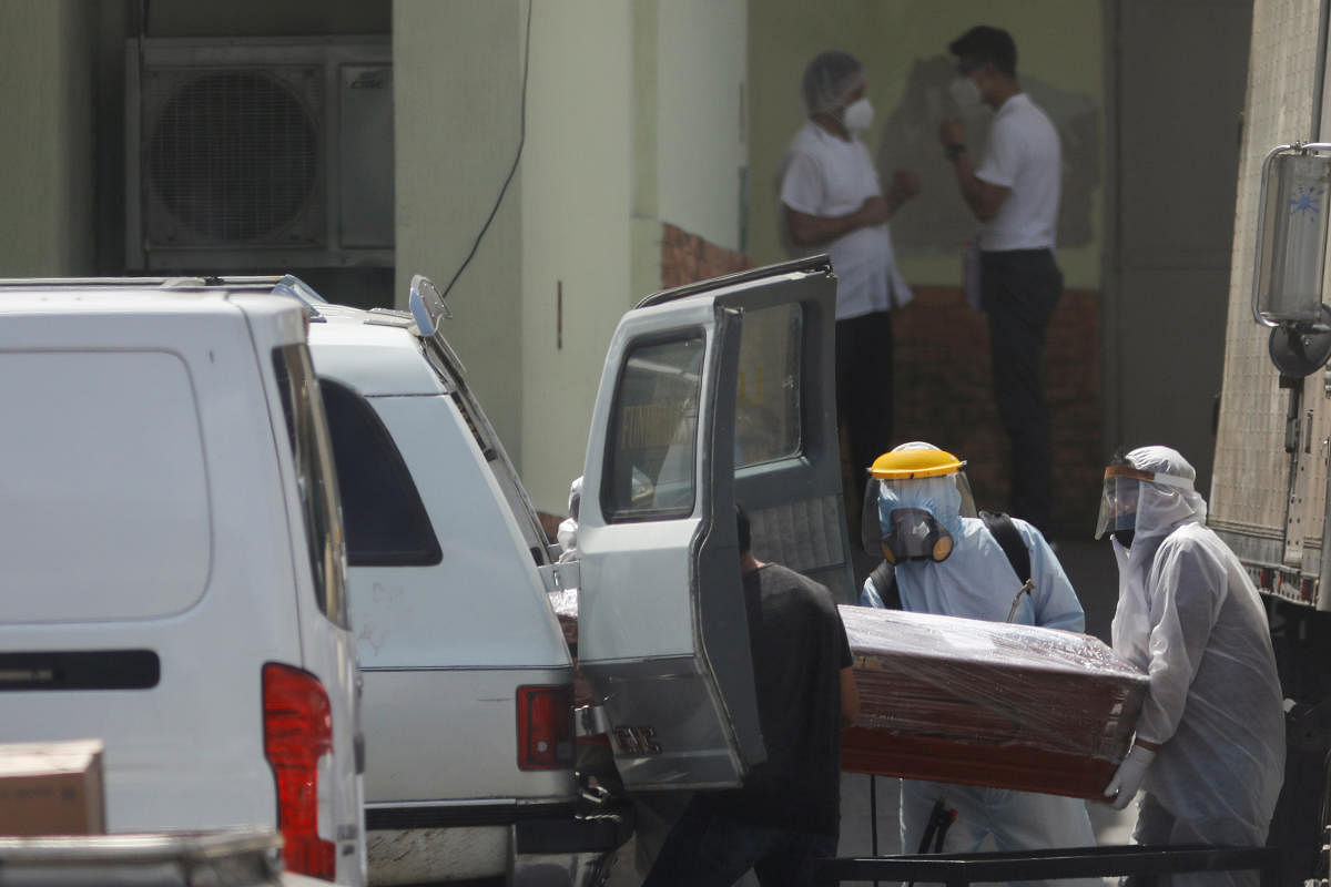 Employees of a funeral parlor carry a coffin with the body of a person who died of the coronavirus disease (COVID-19) at the morgue of the Guatemalan Institute of Social Security. Credit: Reuters