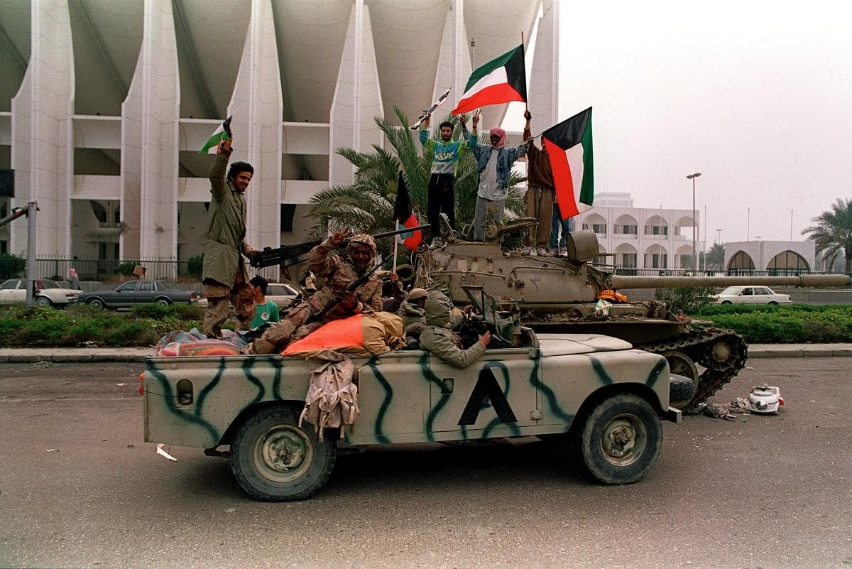  In this file photo taken on February 28, 1991, people with rifles and Kuwaiti national flags celebrate in the streets of Kuwait City after US President George Bush's announcement of a cease-fire. Credit: AFP File Photo