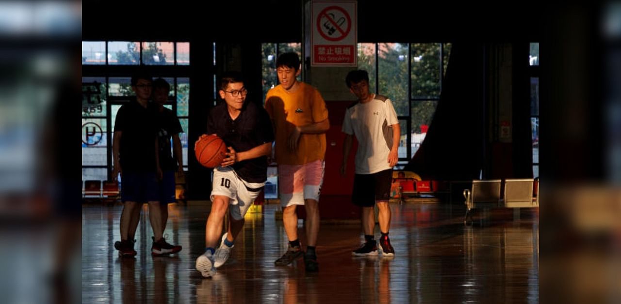 People play basketball in an indoor arena following an outbreak of the coronavirus disease. Representative Photo. Credit: Reuters