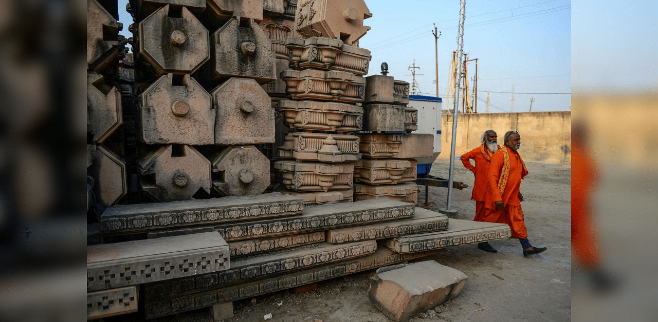  Devotees walk past stone slabs earmarked for the construction of Ram temple. Credit: AFP