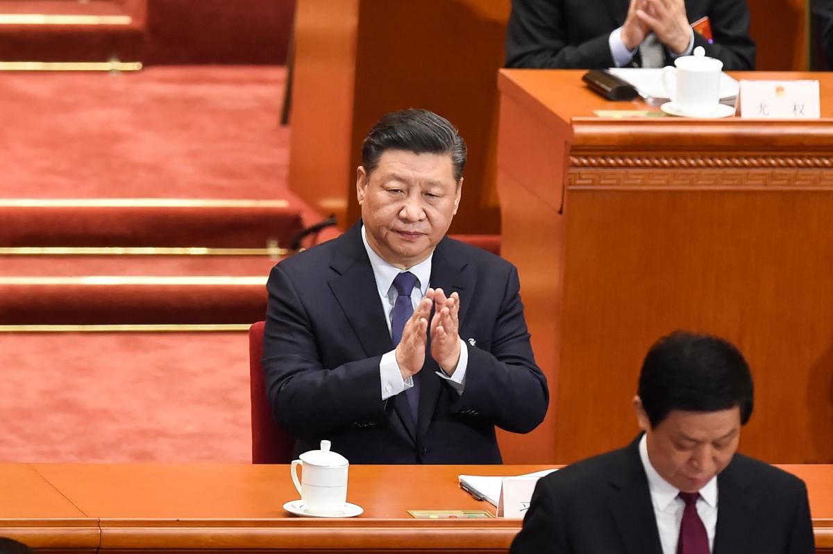 (FILES) This file photo taken on March 5, 2019 shows China's President Xi Jinping applauding during the opening session of the National People's Congress (NPC) at the Great Hall of the People in Beijing. - China's biggest political event of the year opens
