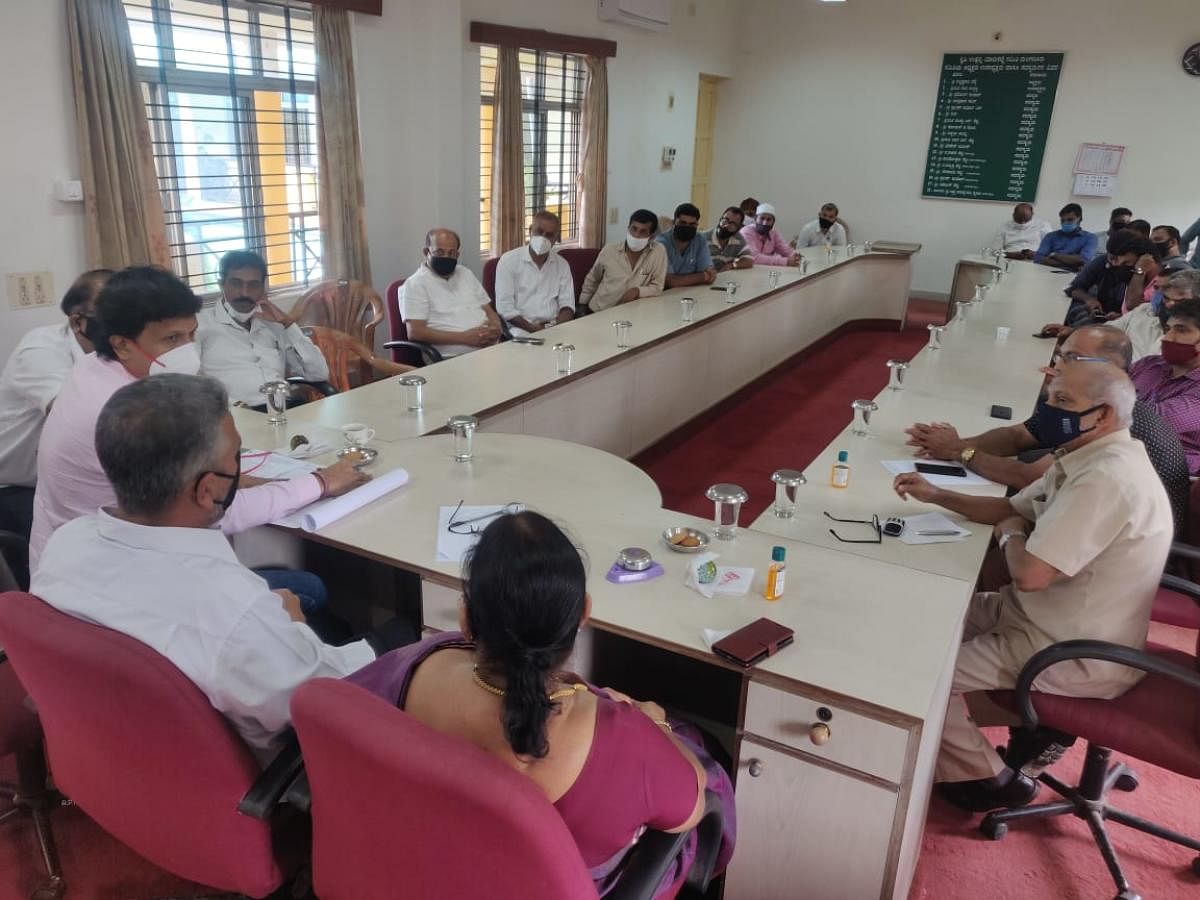 MLA Bharath Shetty Y, APMC President Krishnaraj Hegde and others at a meeting at APMC in Baikampady.