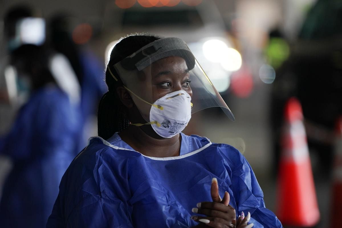 A medical worker in PPE looks on at a drive-thru Covid-19 testing site at the Mahaffey Theater on July 24, 2020 in St. Petersburg, Florida. Credit: AFP Photo