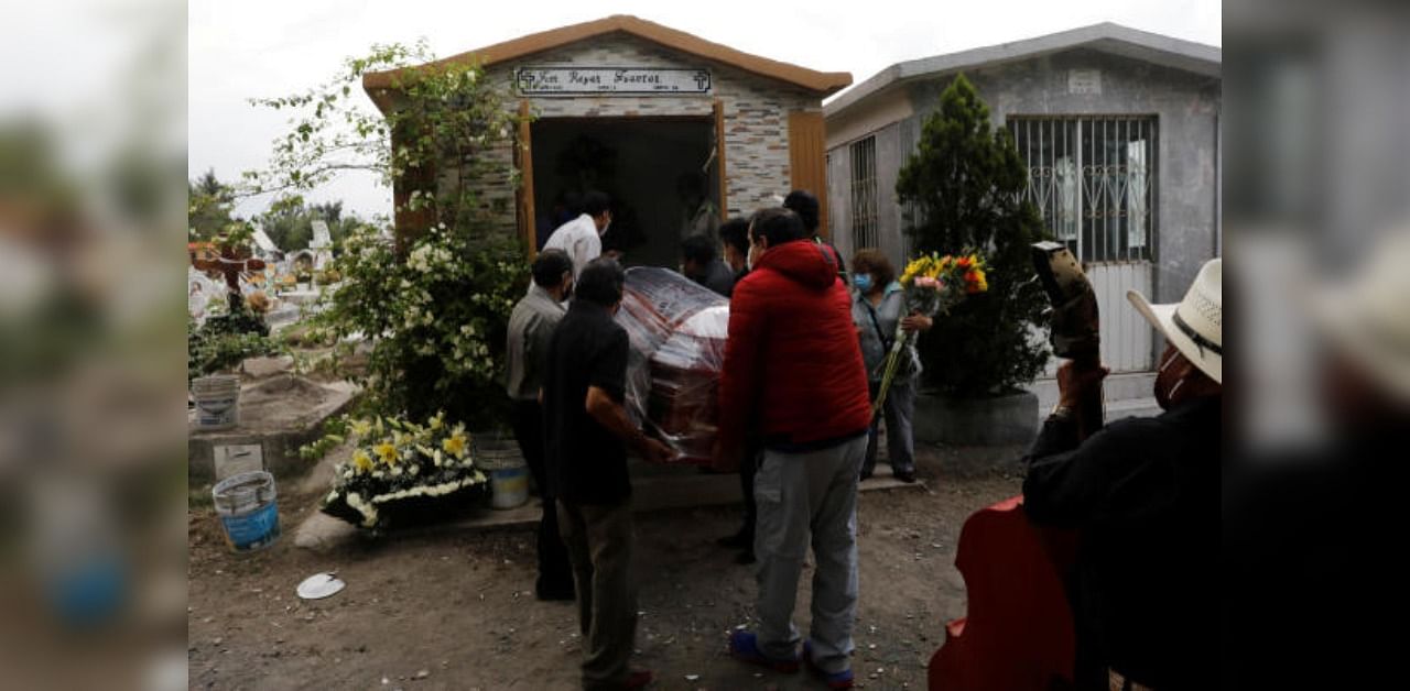 Funeral workers and family members carry a coffin containing the body of a person who died from the coronavirus disease (Covid-19), into a grave at the San Lorenzo Tezonco cemetery in Mexico City, Mexico. Credit: Reuters Photo