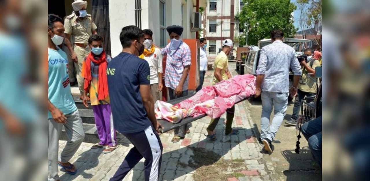 People carry the mortal remains of a victim who died in a hooch tragedy, at Civil Hospital in Tarn Taran district. Credit: PTI