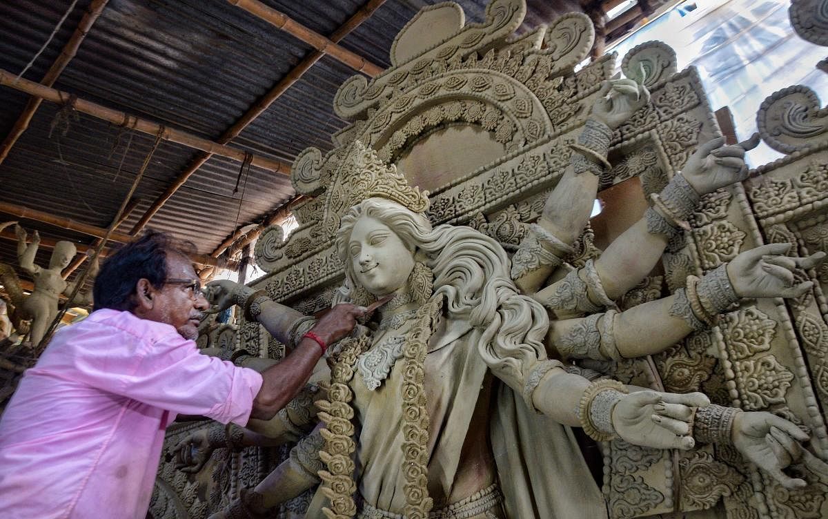 An artist makes a clay idol of Goddess Durga for puja festivities. Credit: PTI