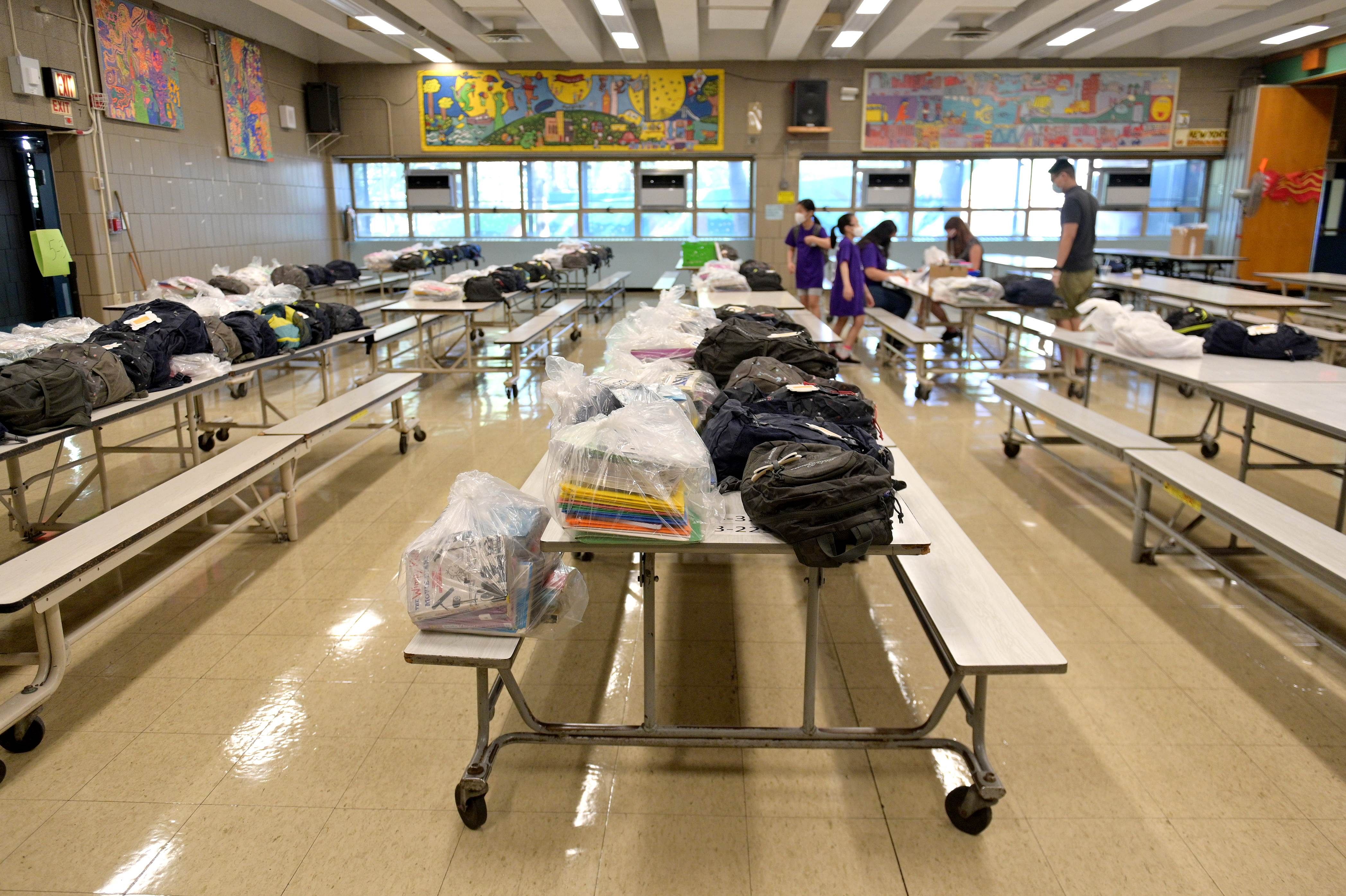 Rows of cafeteria tables are reserved for gifts and personal items left behind before schools were shut down to be picked up by students who just graduated at Yung Wing School P.S. 124 on June 29, 2020 in New York City. In April, it was announced that NYC public schools would be closed at least through the end of the school year amid the spread of coronavirus (COVID-19). Credit: Getty Images/AFP